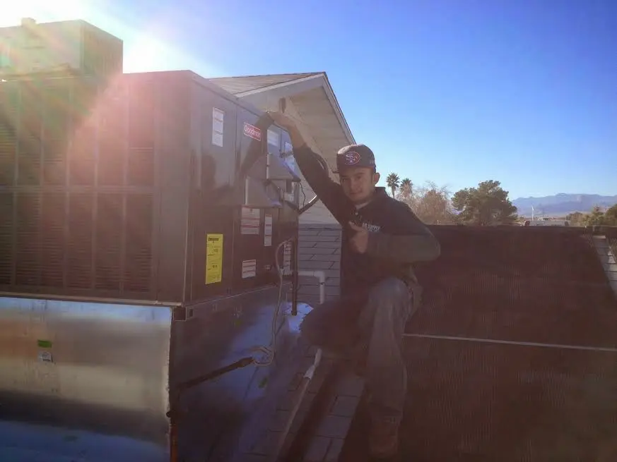 HVAC technician performing HVAC Inspection on a rooftop unit in Redmond